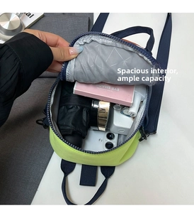 Interior view of mini crossbody bag showing storage for phone, cosmetics, and umbrella