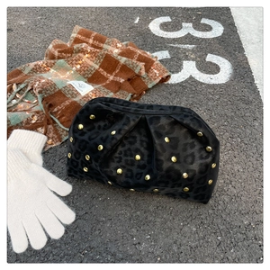Detail of velvet leopard print clutch with gold studs and ruched cloud shape design