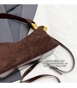 Detailed view of dark brown suede and smooth leather textures with a gold buckle