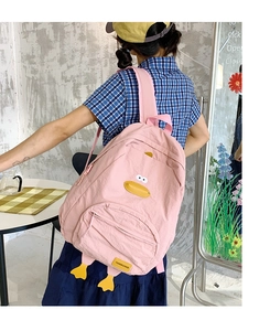 Detailed view of pink cartoon duck backpack with stitched features and front zip pocket