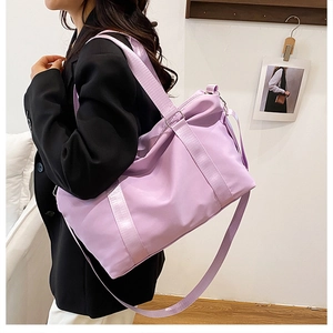 Spacious lavender travel bag for fitness shown worn over the shoulder by a model