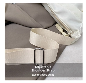 Detail of adjustable woven shoulder strap with silver metal buckle on a white tote bag