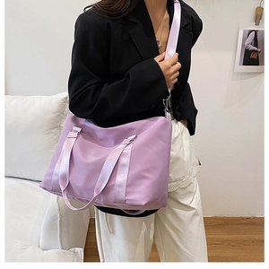 Detail of lavender nylon tote bag with wide straps shown in a minimalist interior setting