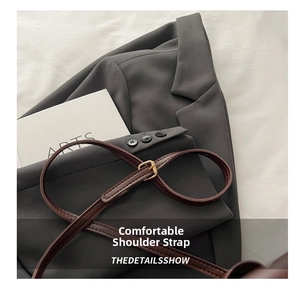 Close-up of dark brown leather strap with gold hardware and fine stitching detail