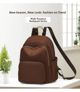 Detail of caramel brown backpack with multiple zippers and wide adjustable straps
