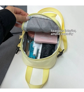 Top view of compact yellow crossbody bag showing spacious interior with daily items