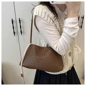 Detail of dark brown woven shoulder bag featuring checkerboard texture and white drawstring