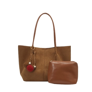 Large brown suede tote bag with woven charm and matching zipper pouch on white background