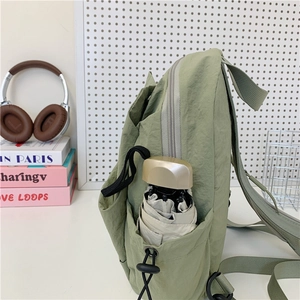 Light green nylon casual backpack with side pocket holding a folding umbrella for daily commute
