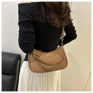Détail d'un sac hobo tressé marron avec bandoulière dorée et logo lettrage de marque