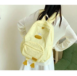 Detail of yellow cartoon duck backpack with plush beak and fashion brand woven label