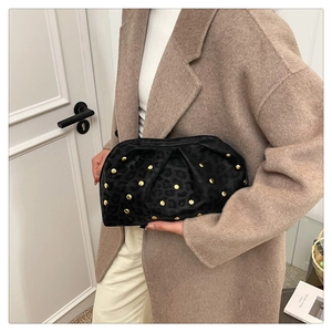 Detail of leopard print velvet clutch with gold metal rivets and cloud fold closure