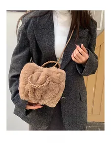 Detail of plush brown faux fur cloud bag with woven handle and leather strap