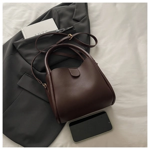 Vue détaillée du sac seau marron foncé avec smartphone pour comparer la taille