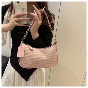 Detail of pink woven crescent bag with gold chain strap and matching brand tag