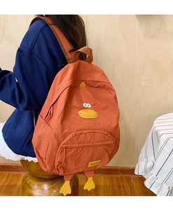 Detail of creative orange duck backpack showing cute 3D feet and fashion label