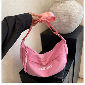 Detailed close-up of pink nylon crescent hobo bag with white FASHION lettering