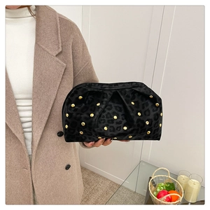 Detail of leopard print velvet cloud clutch bag featuring elegant gold rivet studs
