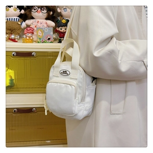 Detailed close-up of white nylon small crossbody bag with smile fashionbag logo