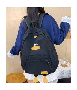 Detail of black cartoon duck backpack featuring creative plush feet and fashion label