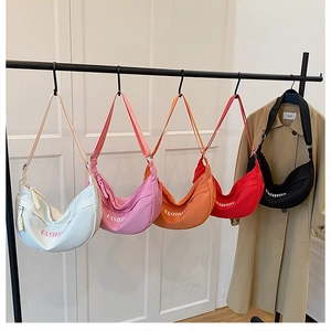 Row of colorful nylon dumpling tote bags hanging showing diverse vibrant color options