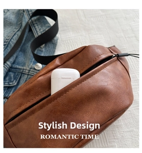 Brown leather crossbody chest bag showing interior capacity with earphone case