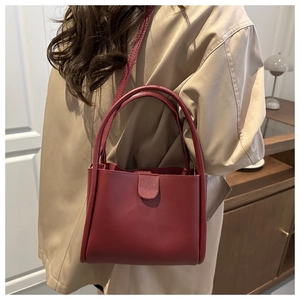 Detail of burgundy leather tote bag showing handle quality and shoulder strap attachment