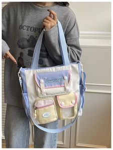 Detail of multi-pocket canvas tote bag with macaron accents and adjustable strap