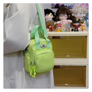 Detail of neon green nylon crossbody bag with dual zippers and smile fashion bag logo