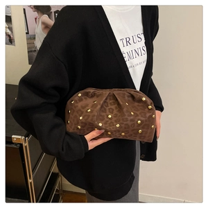 Detail of leopard print cloud clutch bag with gold studs and stylish ruched texture