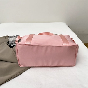 Pink waterproof travel bag with wide handles and adjustable strap for sports or short trips