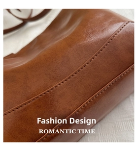 Detailed close-up showing fine stitching and premium leather texture of the brown tote bag