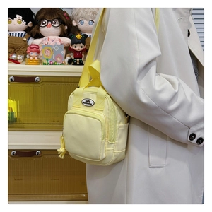 Close-up of yellow shoulder bag with zipper pocket and smile fashionbag label detail