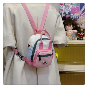 Detailed view of mini color-block backpack with adjustable straps on a person's back