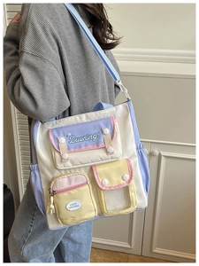 Detail of multi-pocket college style tote bag with pastel color-block design on model