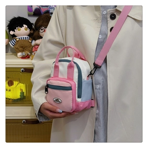 Detailed view of mini multi-functional crossbody bag in pink, blue, and white patchwork