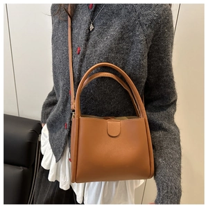 Close-up of brown synthetic leather tote bag with elegant magnetic flap and adjustable strap