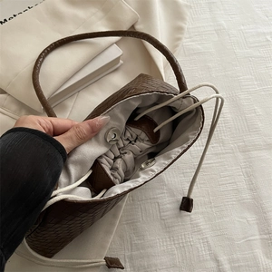 Brown woven PU leather handbag with drawstring interior and metal magnetic closure