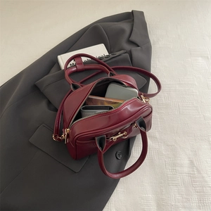 Retro burgundy leather handbag with gold horsebit hardware and adjustable shoulder strap