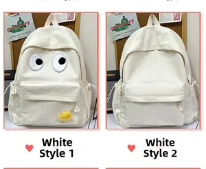 Detail of two white corduroy backpacks with cute eye embroidery and minimalist design