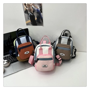 Detailed macro view of three colorful nylon mini backpacks with contrast zippers and front logos