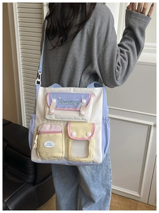 Detail view of multi-pocket contrast crossbody bag with transparent window and colorful strap