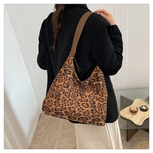Détail d'un grand sac cabas à imprimé léopard avec une bandoulière en cuir porté