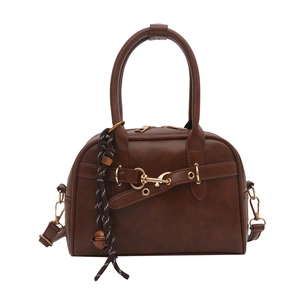 Brown vintage shell crossbody bag with golden buckle and woven bell charm