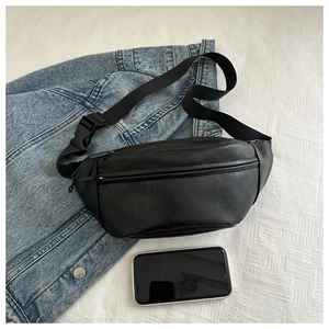 Detailed view of black PU leather waist bag capacity shown with smartphone and denim jacket