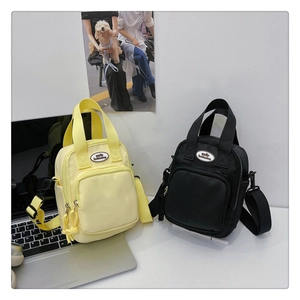 Dual-color mini crossbody bag detail showing yellow and black nylon fabric texture