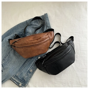 Close-up of black and brown semi-circular PU leather chest bags with adjustable straps