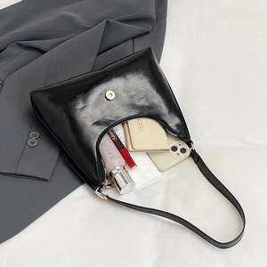 Glossy black underarm bag for women with polished finish and curved zipper design