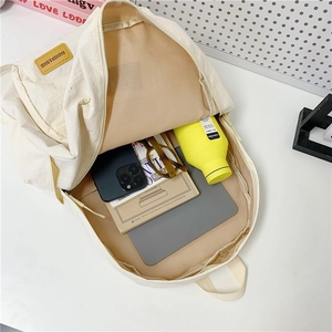 Minimalist beige campus backpack showing spacious interior with tablet and daily essentials