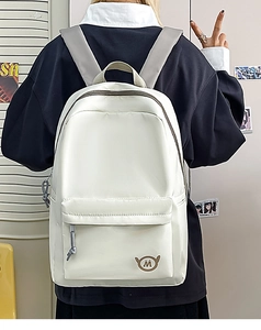 Detail of off-white nylon backpack showing the durable fabric and round M logo patch